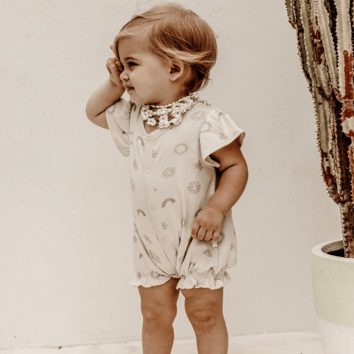 Beautiful-Little-Girl-Wearing-Aster-and-Oak-Organic-Sunny-Daze-Ruffle-Romper-Naked-Baby-Eco-Boutique