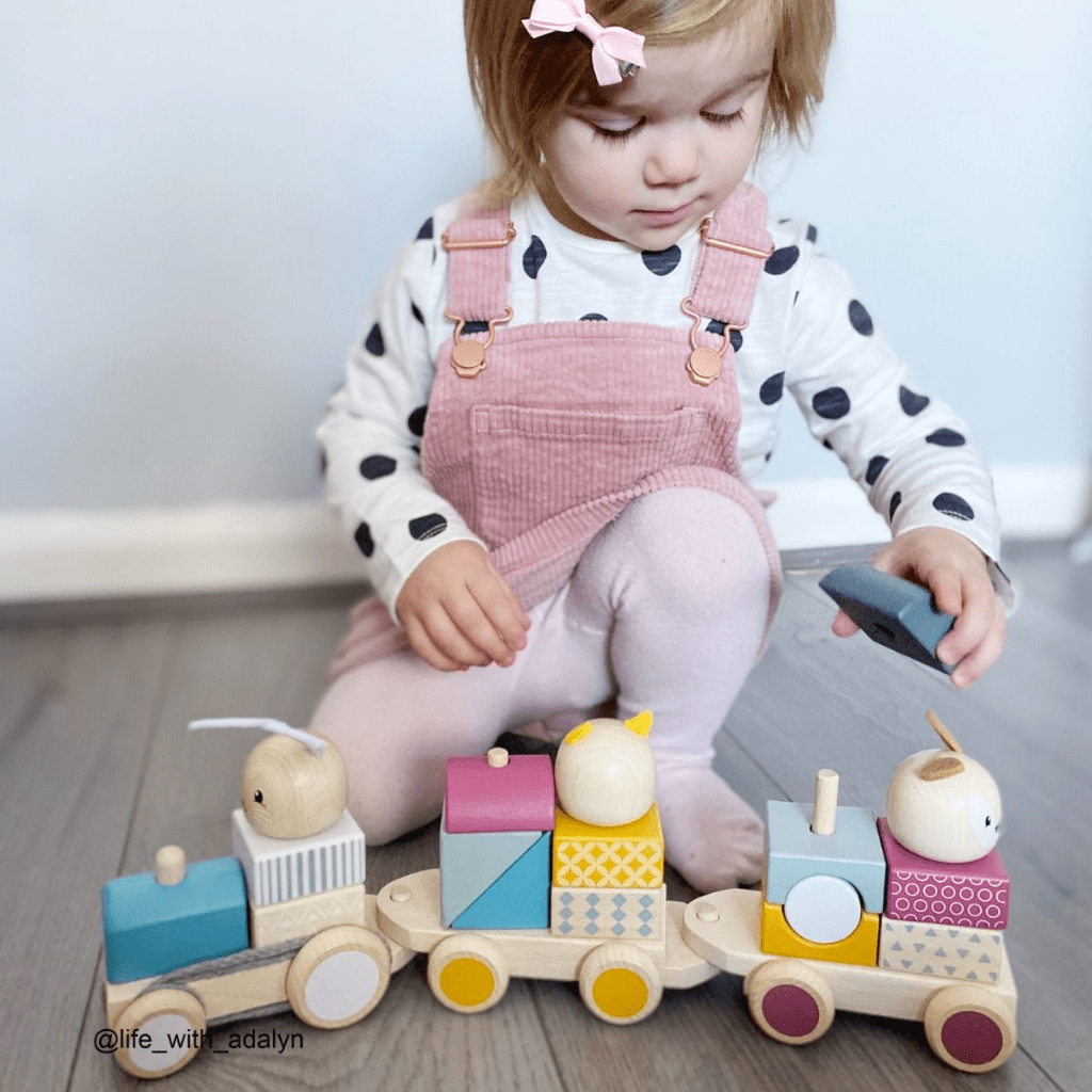 Bigjigs-Wooden-Activity-Pull-Along-Train-Little-Girl-Putting-Blocks-On-Train-Naked-Baby-Eco-Boutique