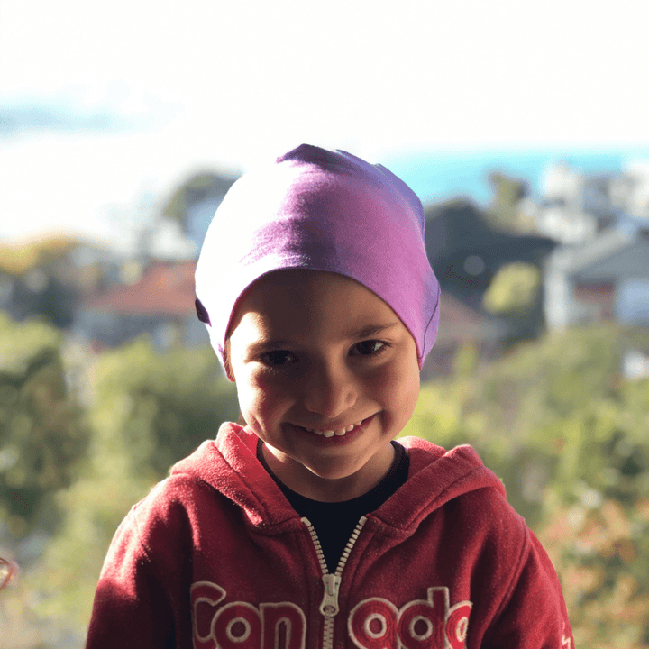 A young boy smiling while wearing an Anarkid Magic Colour-Change Beanie (Multiple Variants) hat.