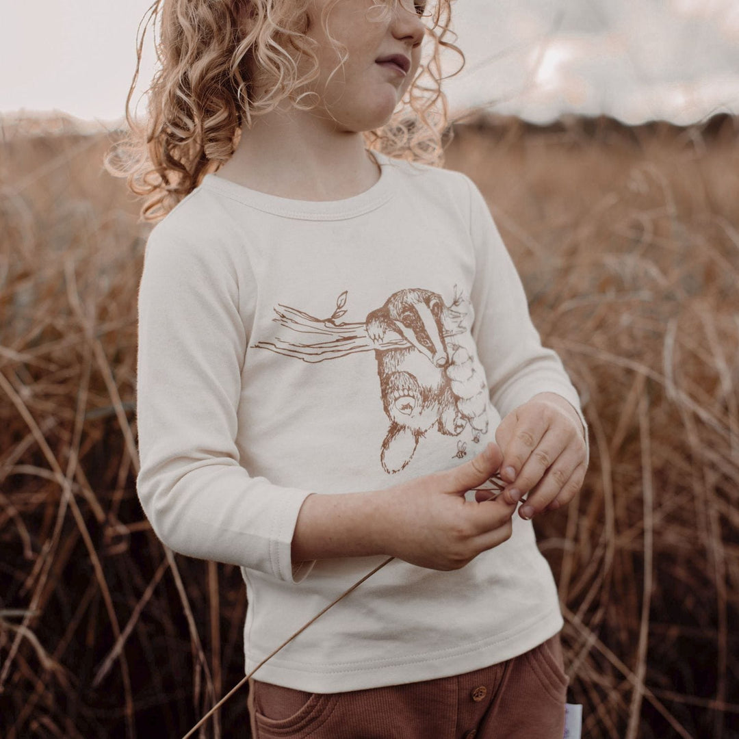 Child-in-Field-Wearing-Aster-and-Oak-Organic-Long-Sleeve-Tee-Badger-Naked-Baby-Eco-Boutique
