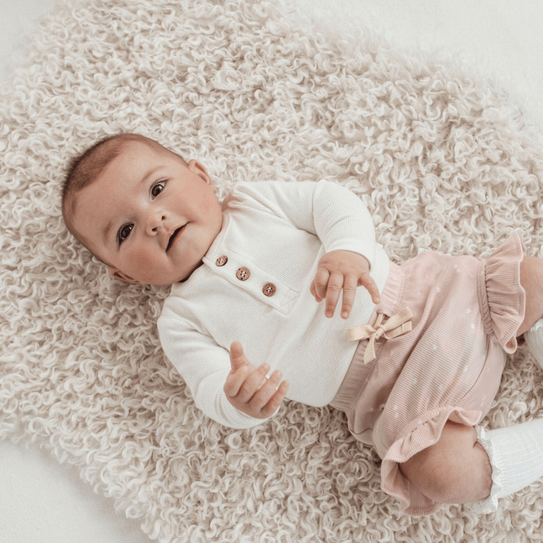 Cute-Baby-Lying-on-Back-Wearing-Aster-and-Oak-Organic-Rib-Onesie-Snow-Naked-Baby-Eco-Boutique