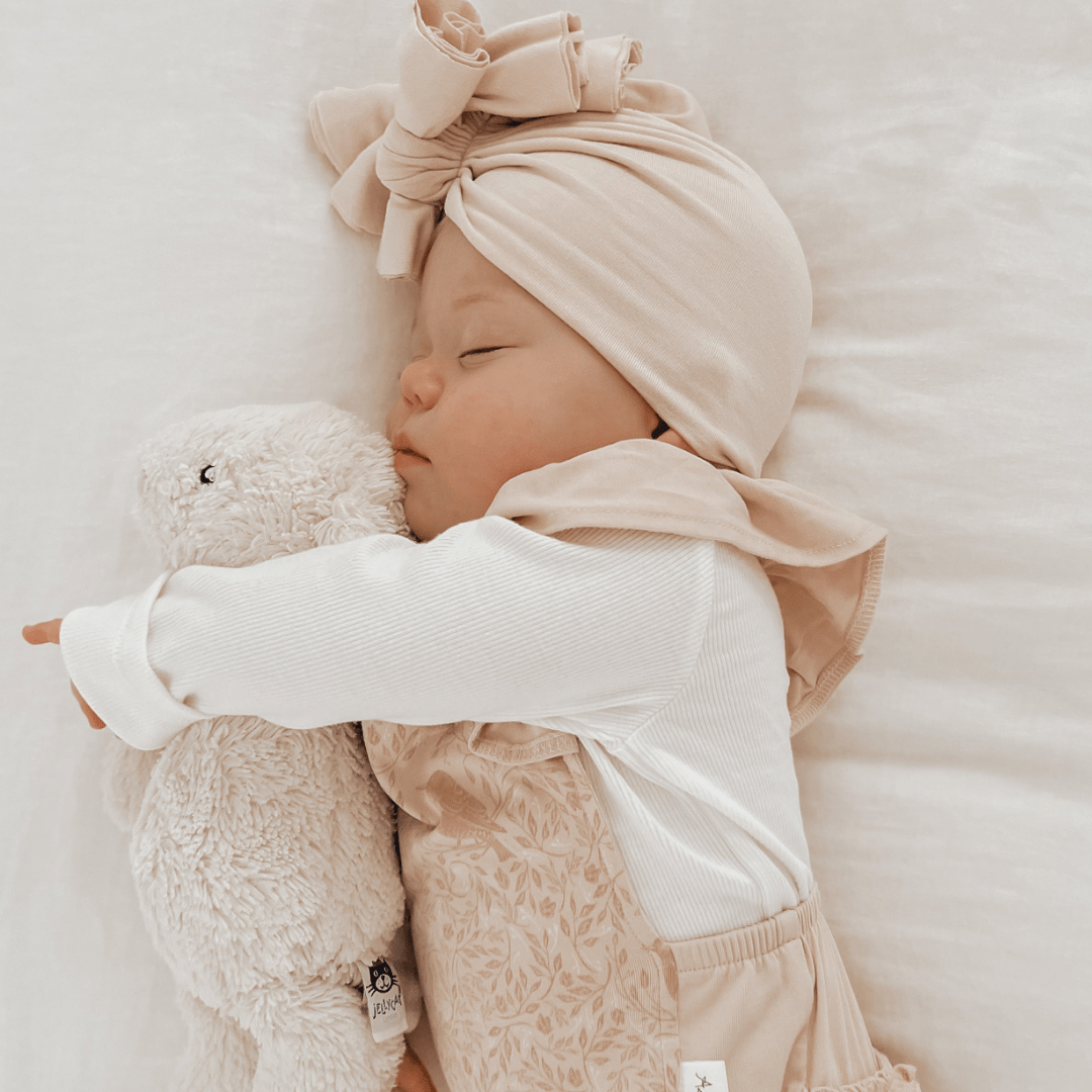 Cute-Baby-Sleeping-Wearing-Little-Girl-Wearing-Aster-and-Oak-Organic-Rib-Henley-Top-Snow-Naked-Baby-Eco-Boutique