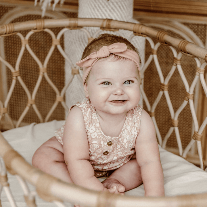 Cute-Baby-in-Bassinet-Wearing-Aster-and-Oak-Ditzy-Floral-Bubble-Romper-Naked-Baby-Eco-Boutique