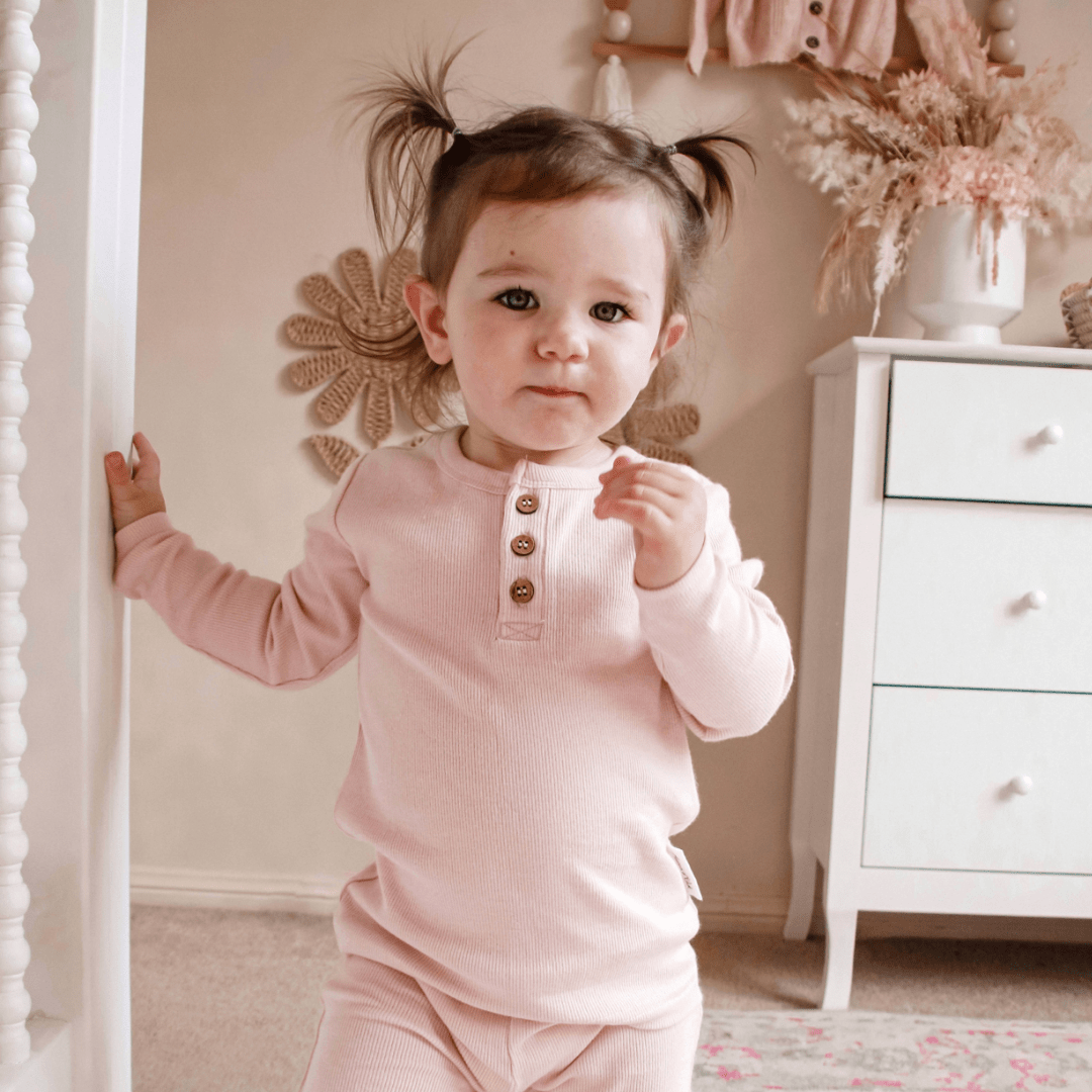 Cute-Girl-with-Pigtails-Wearing-Aster-and-Oak-Organic-Rib-Henley-Top-Blush-Naked-Baby-Eco-Boutique
