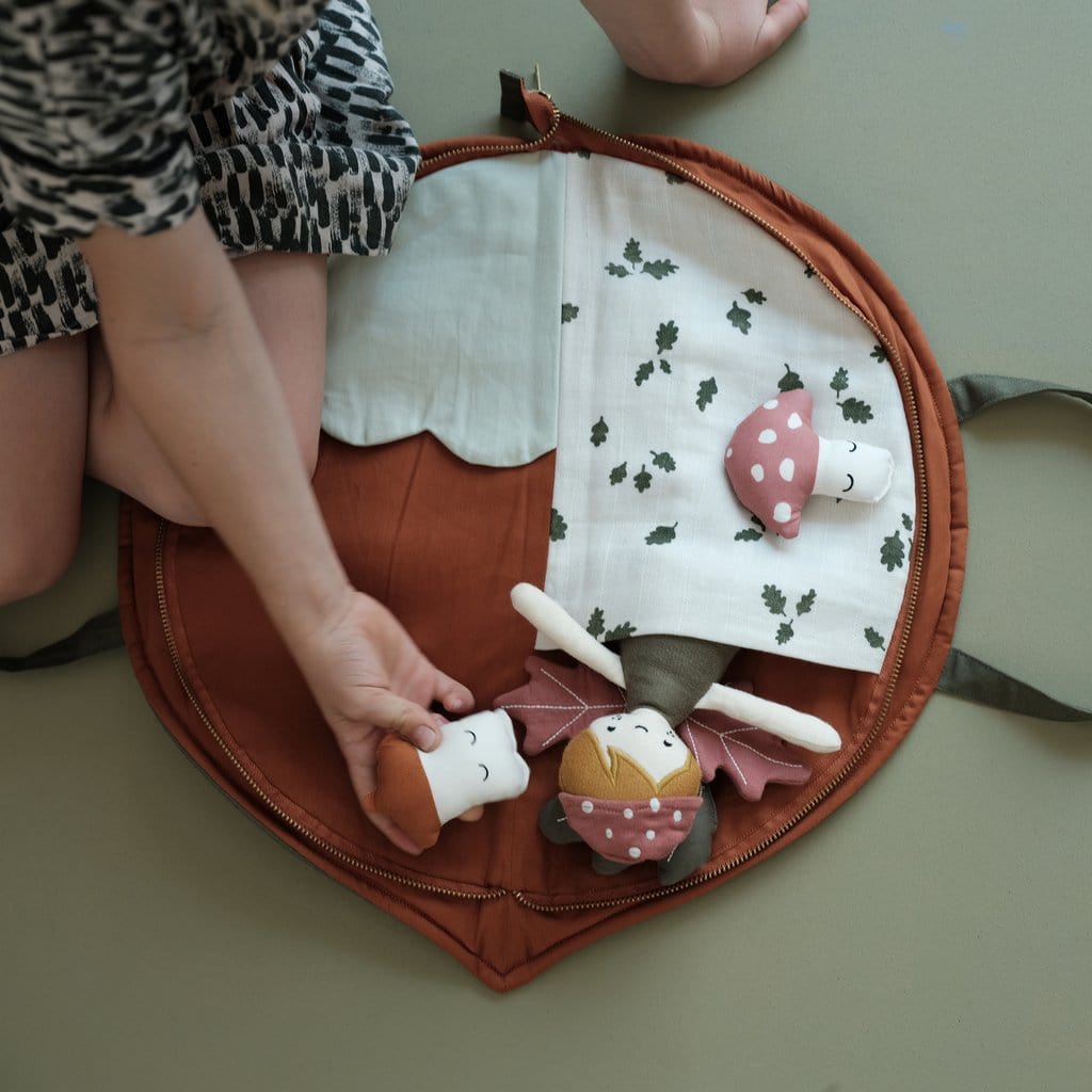 A child is playing with a Fabelab Organic Cotton Play Purse on the floor.
