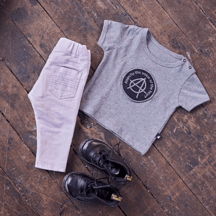 An Anarkid grey t-shirt and black shoes on a wooden floor, showcasing an Anarkid Organic Cotton Jeggings - LUCKY LASTS - 3-6 MONTHS & 6-12 MONTHS ONLY.