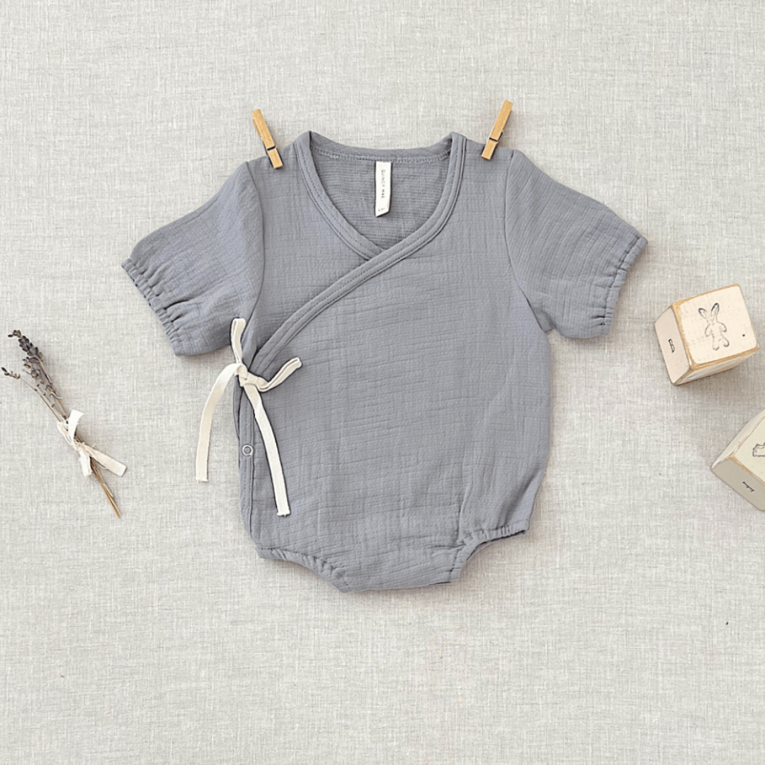 Flatlay-of-Quincy-Mae-Organic-Cotton-Woven-Wrap-Onesie-Washed-Indigo-Naked-Baby-Eco-Boutique