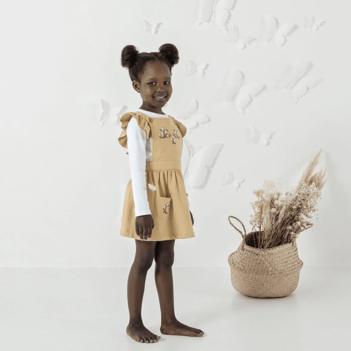 Happy-Girl-Wearing-Aster-And-Oak-Organic-Cotton-Embroidered-Pinafore-Dress-Taupe-Floral-Naked-Baby-Eco-Boutique