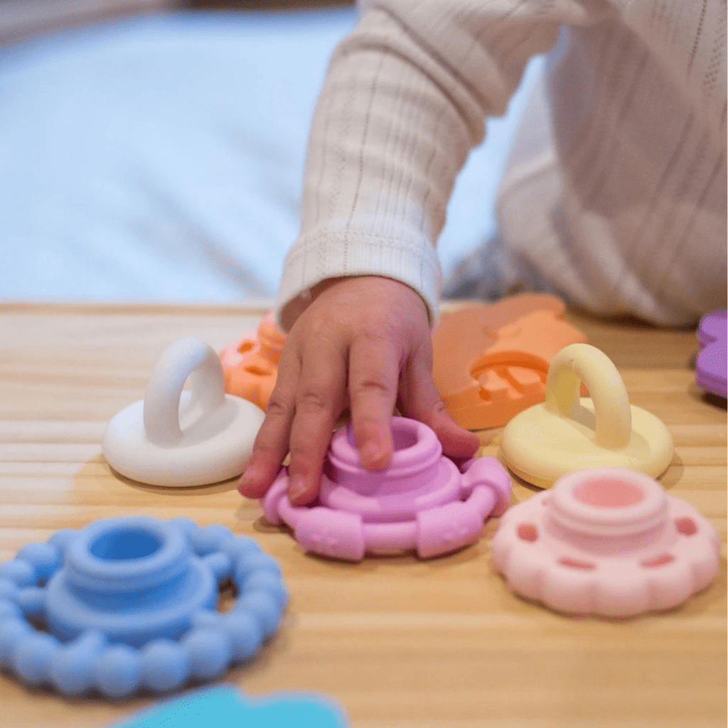 Jellystone-Desogns-Silicone-Rainbow-Stacker-Baby-Playing-With-Pastel-Stacker-Naked-Baby-Eco-Boutique