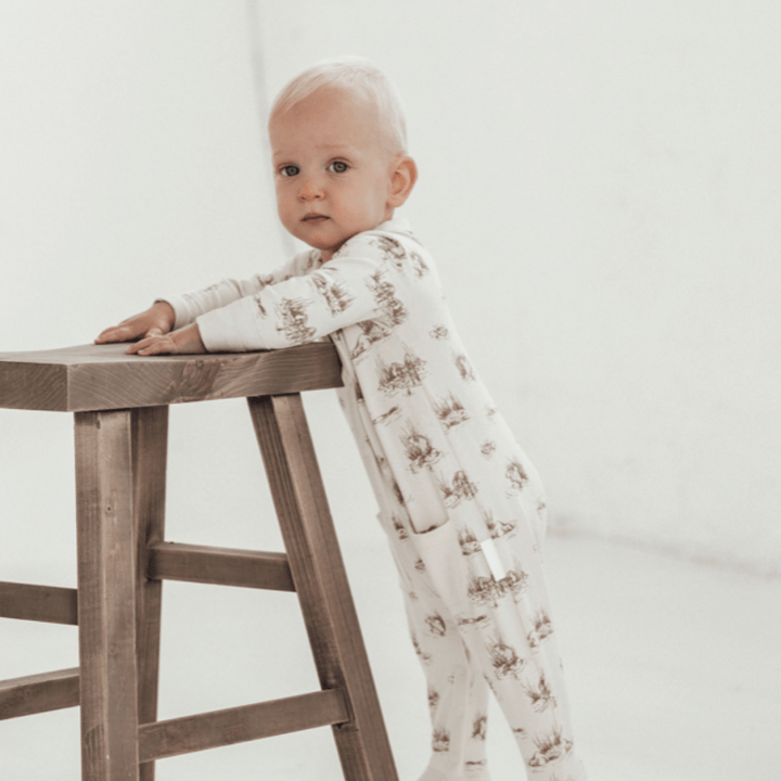 Little-Baby-Standing-Wearing-Aster-And-Oak-Organic-Cotton-Baby-Pyjamas-Beaver-Naked-Baby-Eco-Boutique  1080 × 1080px