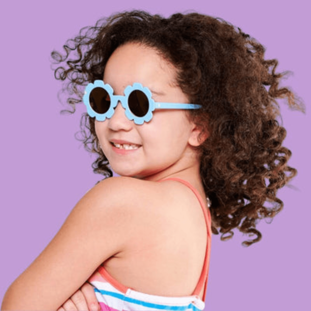 Little-Girl-Looking-Over-Shoulder-Wearing-Babiators-Flower-Polarized-Baby-Kids-Sunglasses-The-Wildflower-Naked-Baby-Eco-Boutique
