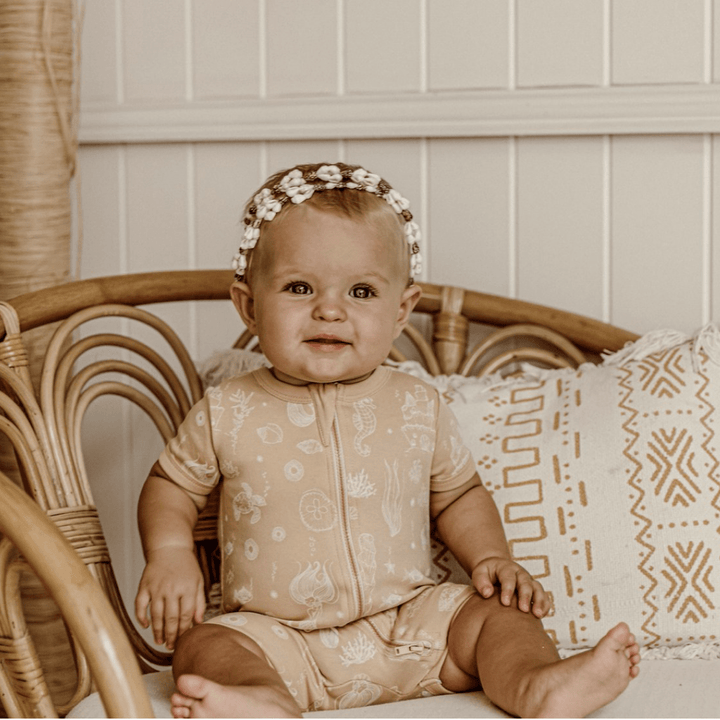 Little-Girl-Looking-at-Camera-Wearing-Aster-and-Oak-Organic-Mermaid-Zip-Romper-Naked-Baby-Eco-Boutique