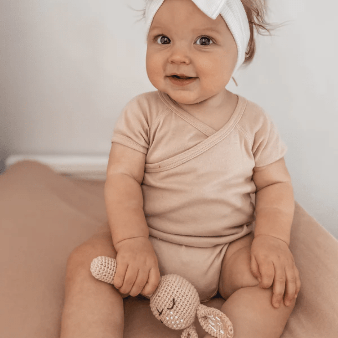 Little-Girl-Playing-With-Over-The-Dandelions-Bunny-Rattle-Blush-Naked-Baby-Eco-Boutique