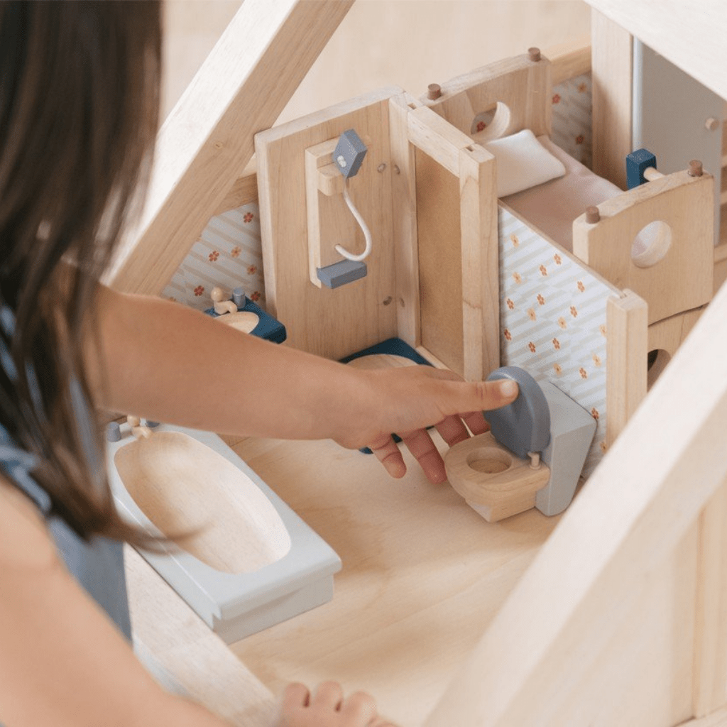 Little-Girl-Playing-with-Plan-Toys-Dollhouse-Bathroom-Furniture-Orchard-Naked-Baby-Eco-Boutique