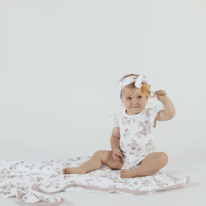 Little-Girl-Sitting-On-Little-Baby-Lying-On-Aster-And-Oak-Organic-Cotton-Baby-Swaddle-Wrap-Primrose-Naked-Baby-Eco-Boutique