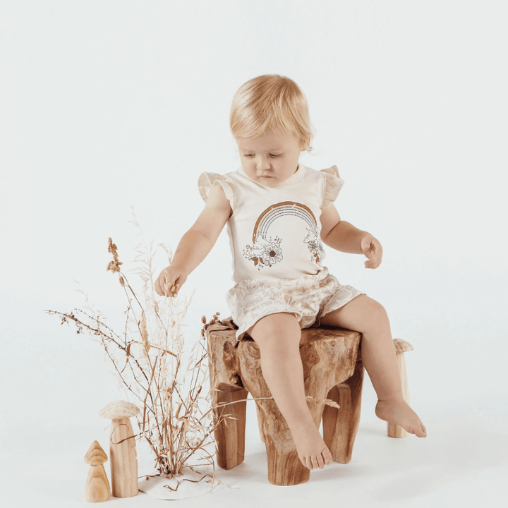 Little-Girl-Sitting-on-Stool-Wearing-Aster-and-Oak-Organic-Ruffle-Bloomers-Fairy-Garden-Naked-Baby-Eco-Boutique