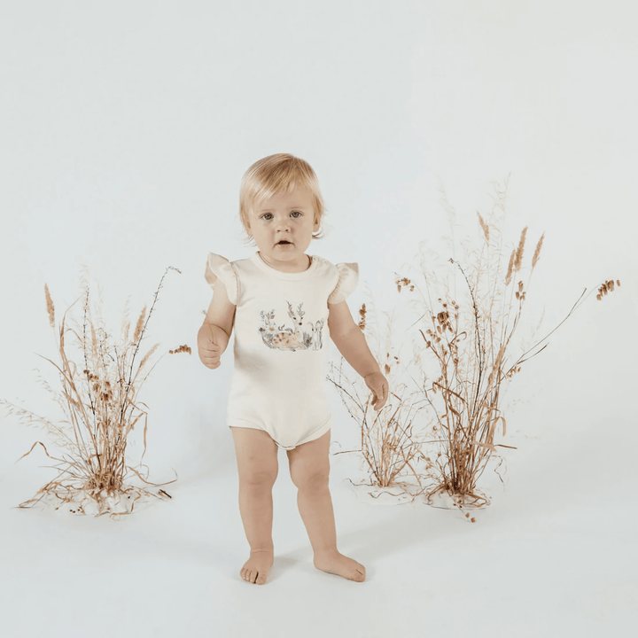 Little-Girl-Wearing-Aster-And-Oak-Organic-Cotton-Prairie-Print-Flutter-Onesie-Naked-Baby-Eco-Boutique