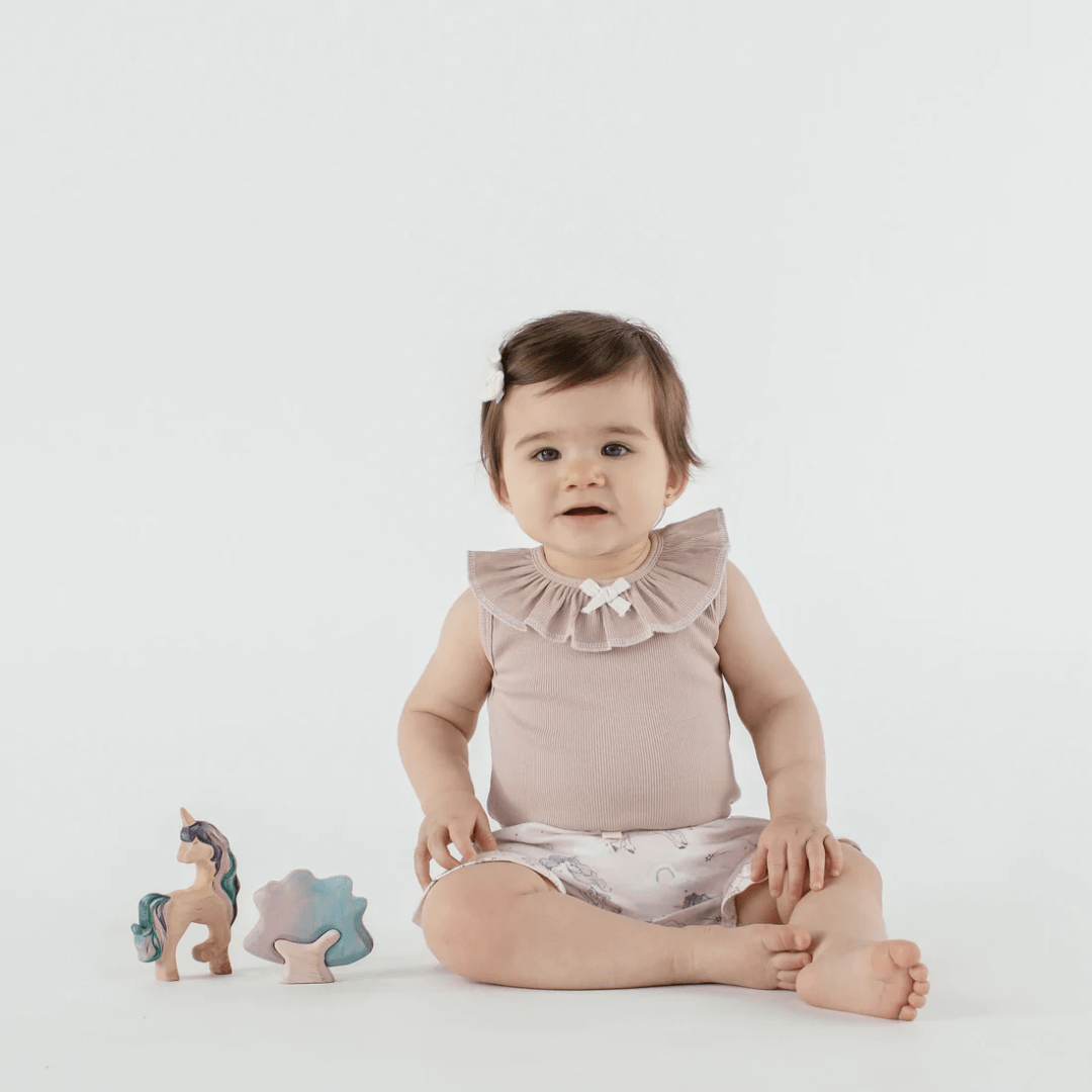Little-Girl-Wearing-Aster-And-Oak-Organic-Mauve-Rib-Ruffle-Onesie-Naked-Baby-Eco-Boutique