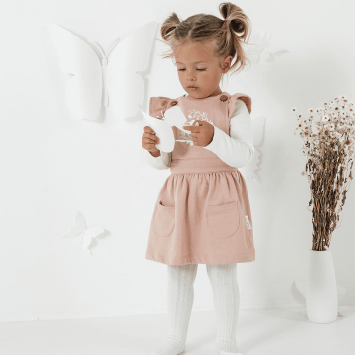 Little-Girl-Wearing-Aster-And-Oak-Organic-Song-Bird-Embroidered-Pinafore-Dress-Naked-Baby-Eco-Boutique