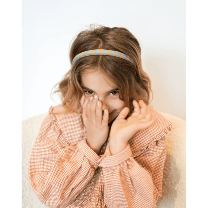 Little-Girl-Wearing-Grech-And-Co-Organic-Cotton-Headbands-Two-Pack-Checks-Laguna-And-Wheat-Naked-Baby-Eco-Boutique