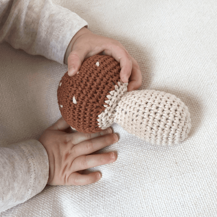 Over-The-Dandelions-Mushroom-Rattle-In-Little-Baby-Hands-Naked-Baby-Eco-Boutique