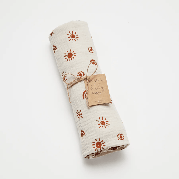 Over-The-Dandelions-Organic-Muslin-Swaddle-Blanket-Sand-Amber-Rolled-Up-With-Tag-Naked-Baby-Eco-Boutique