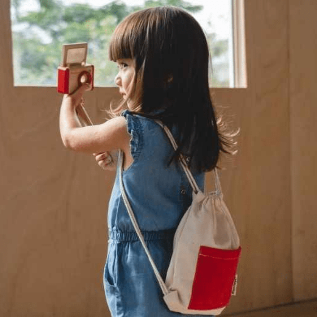 Plan-Toys-Vlogger-Kit-Little-Girl-Taking-Selfie-With-Bag-On-Naked-Baby-Eco-Boutique
