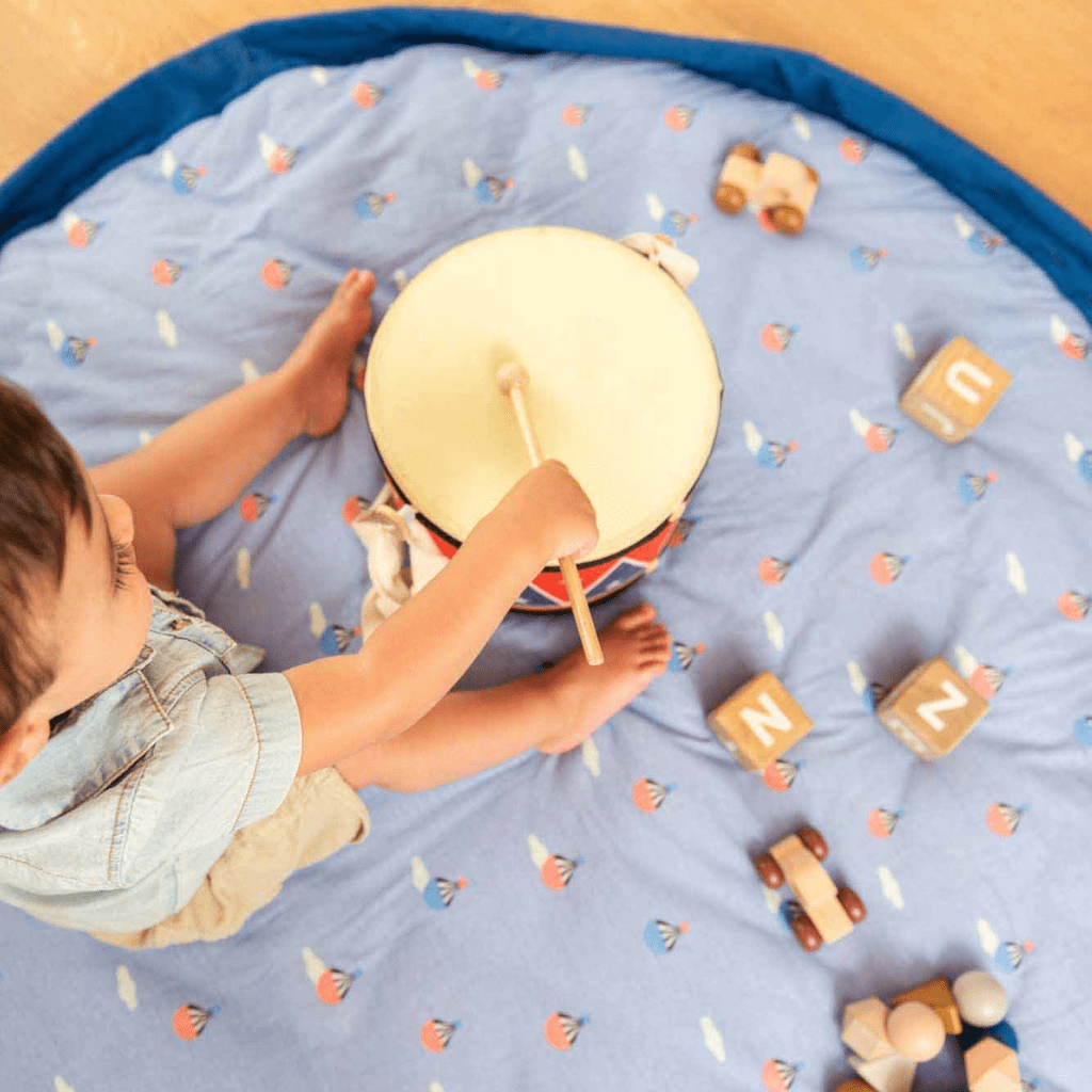 Play-And-Go-Soft-Toy-Storage-Bag-And-Playmat-Hot-Air-Balloon-Little-Boy-Playing-With-Drum-On-Mat-Naked-Baby-Eco-Boutique.
