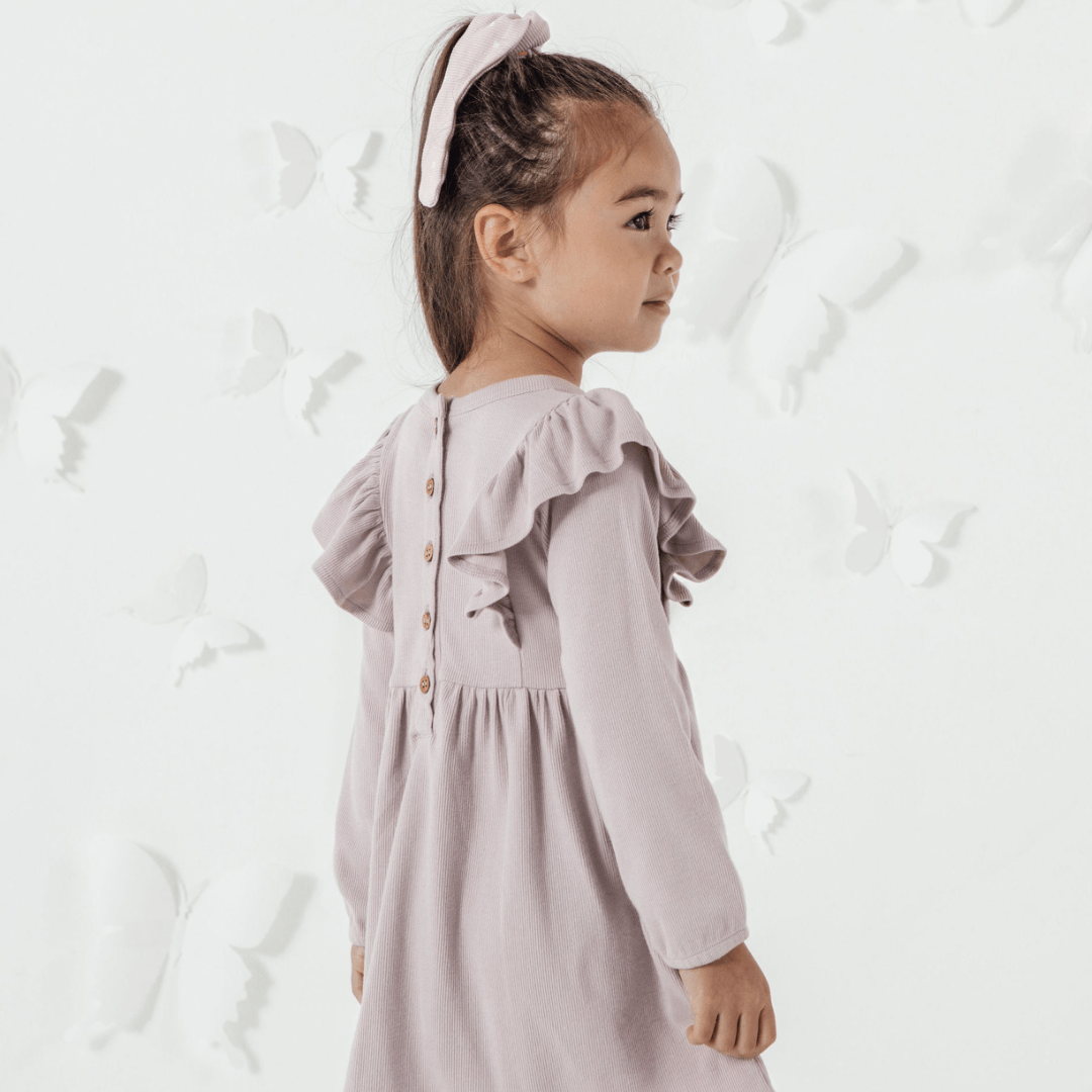 Side-View-of-Girl-Wearing-Aster-and-Oak-Organic-Rib-Ruffle-Dress-Violet-Naked-Baby-Eco-Boutique