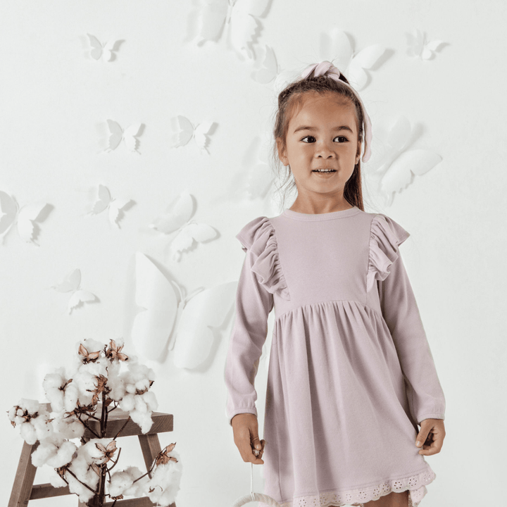 Smiling-Little-Girl-Wearing-SideAster-and-Oak-Organic-Rib-Ruffle-Dress-Violet-Naked-Baby-Eco-Boutique